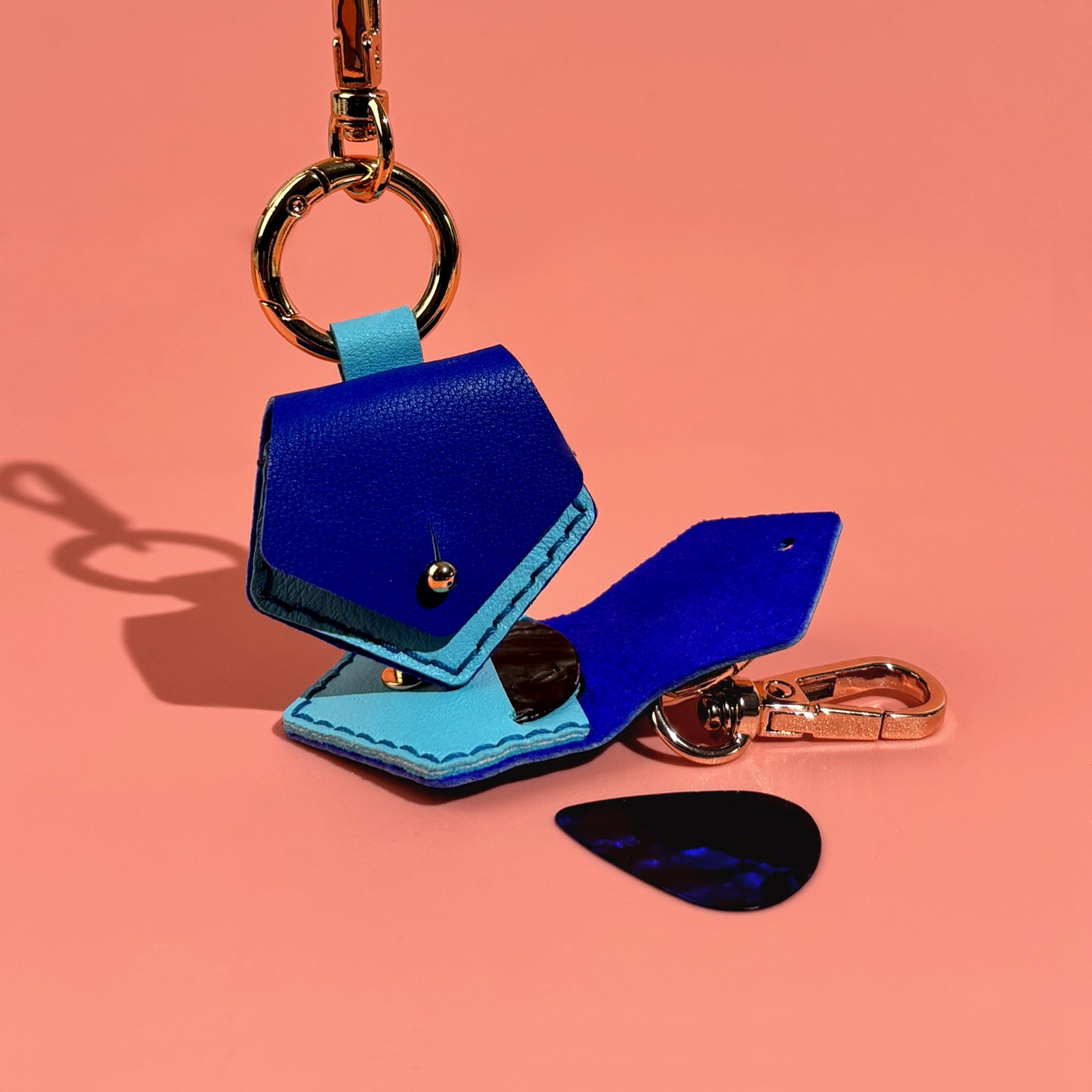 Unique hexagonal blue leather plectrum holder key ring, artisan crafted for easy attachment to bags or instrument cases, ensuring picks are always at hand.