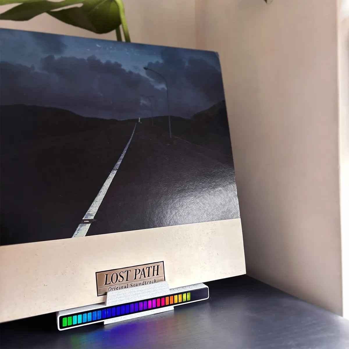 LLKworks audio visualizer vinyl stand with reactive LED lights showcasing an album cover on a wooden setup.
