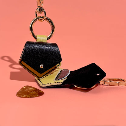 Unique hexagonal black leather plectrum holder key ring, artisan crafted for easy attachment to bags or instrument cases, ensuring picks are always at hand.