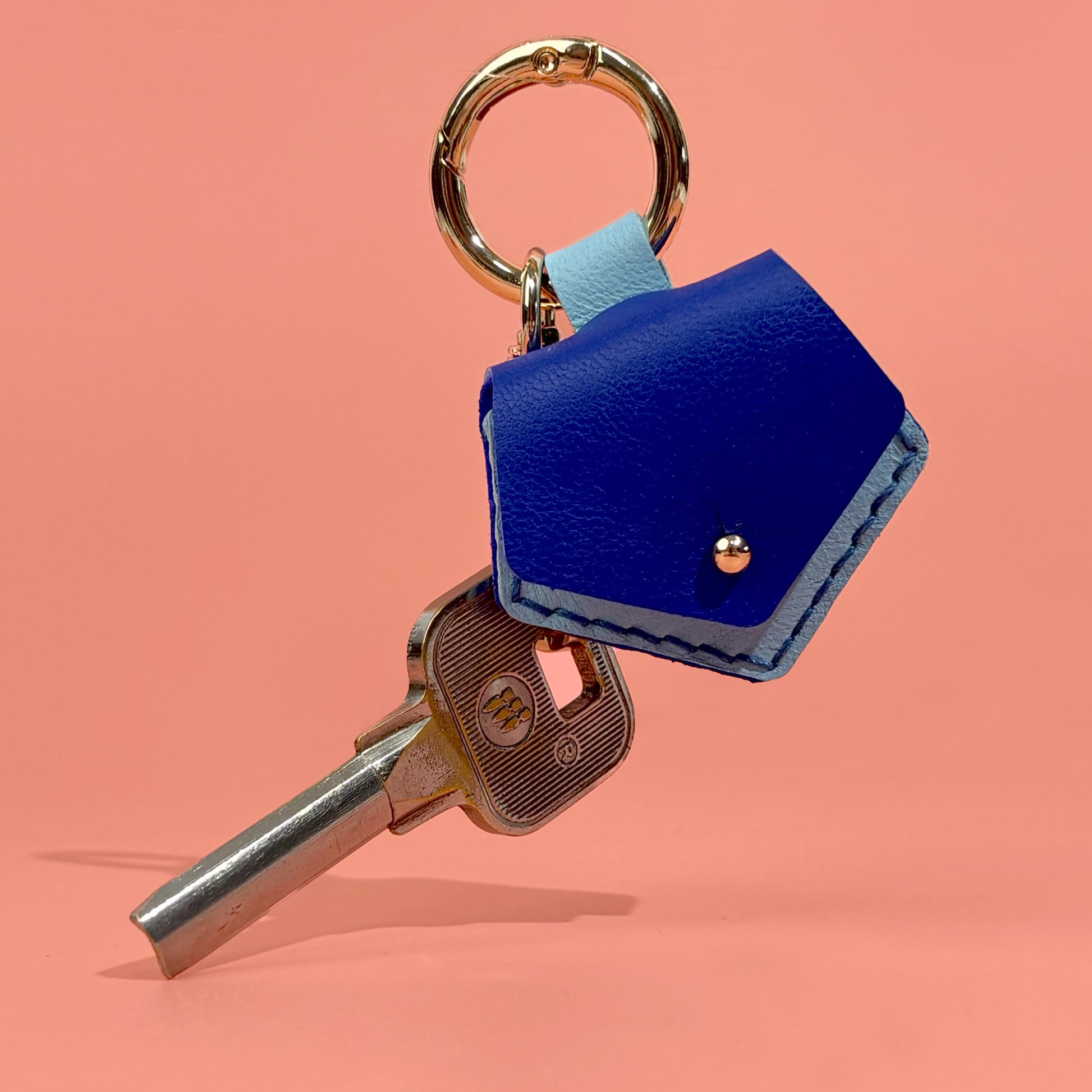 Vibrant blue handmade leather guitar pick case keychain, designed for musicians seeking a convenient and elegant solution for both pick and key safekeeping.