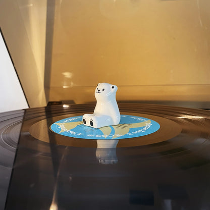 Cute polar bear ceramic vinyl record decor sitting on a spinning turntable record player