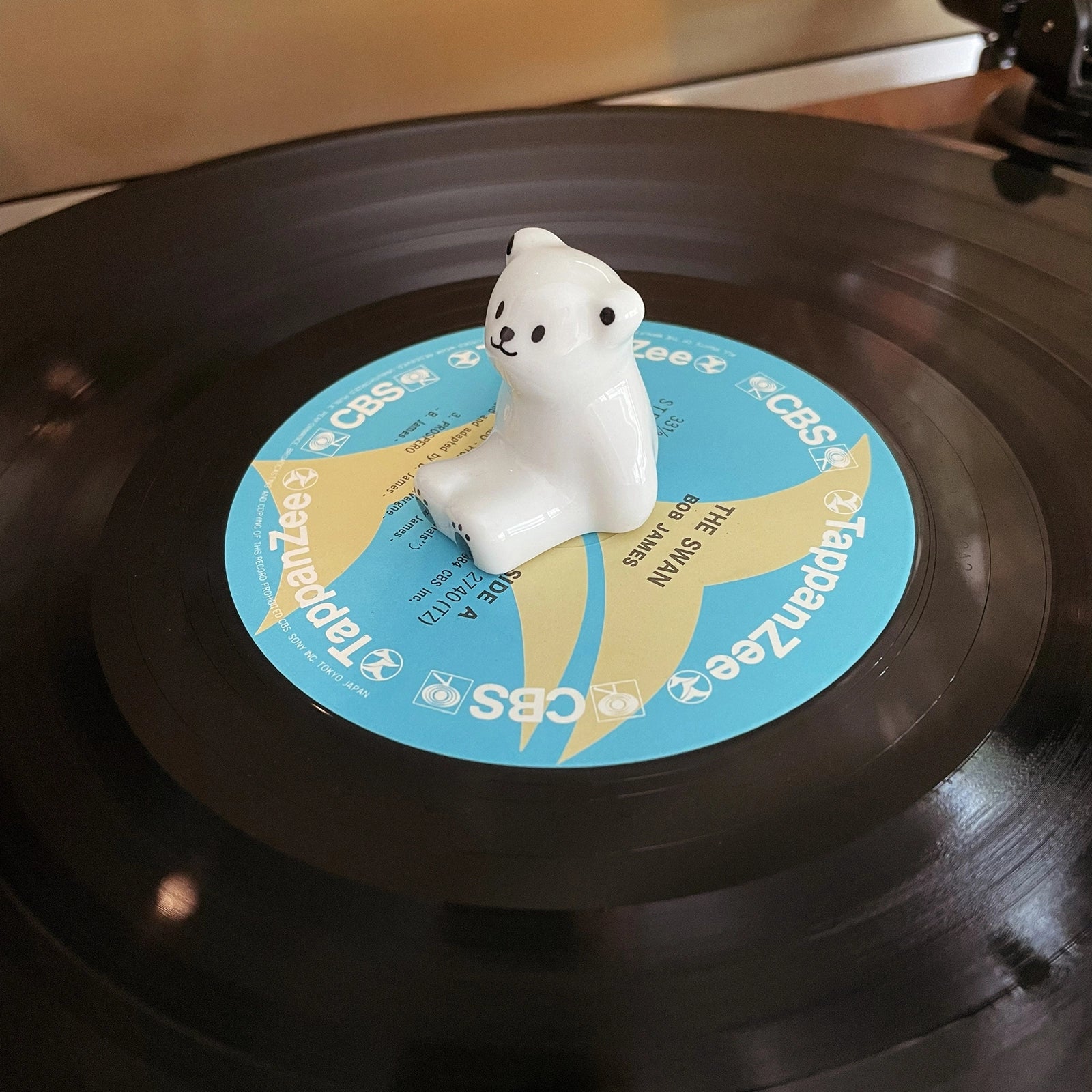 Top view of ceramic polar bear center figurine resting on vinyl record label