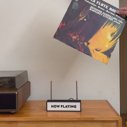 Now Playing vinyl record stand with automatic light-up sensor, showing desktop and wall-mount display options.