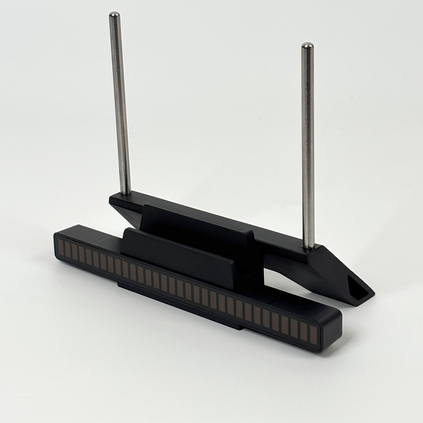 Modern minimalist design of black vinyl record stand with stainless steel support rods.
