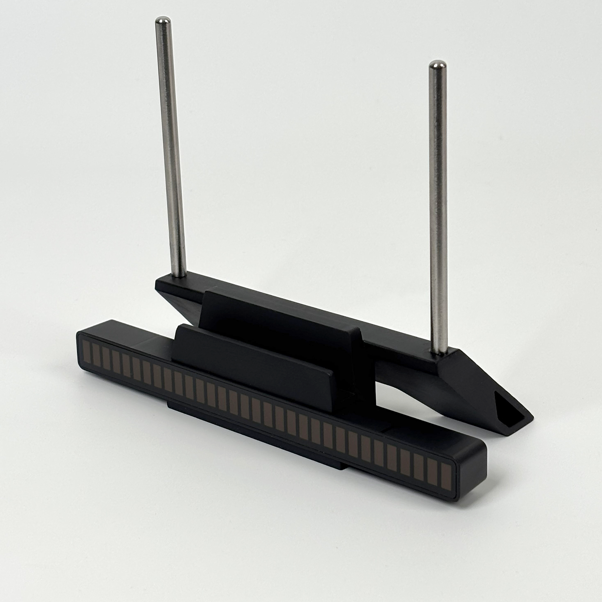 Modern minimalist design of black vinyl record stand with stainless steel support rods.
