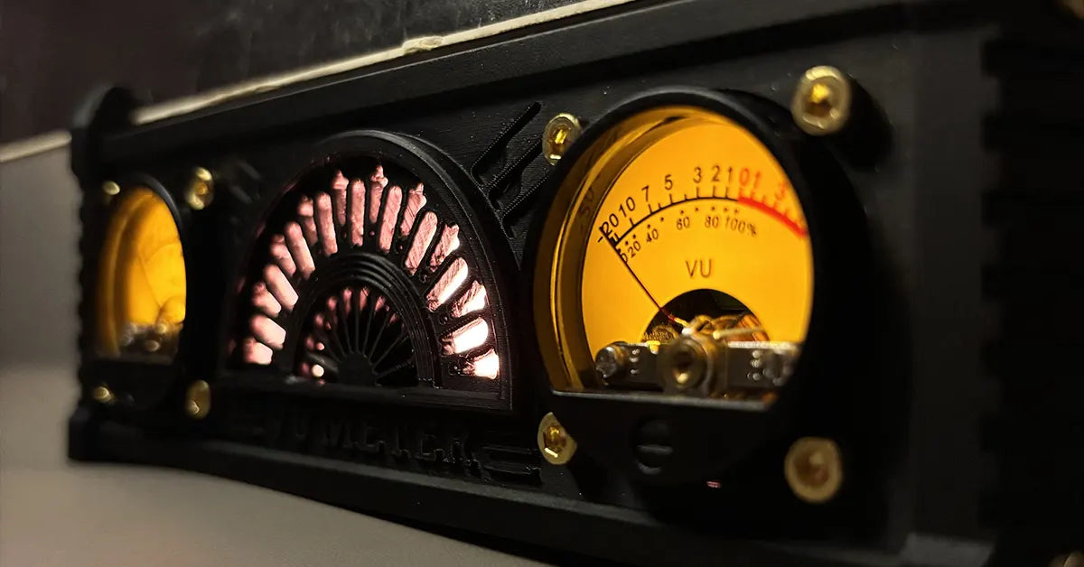 LLKworks now playing record stand featuring a retro dual VU meter and glowing analog display on a minimalist desktop setup.